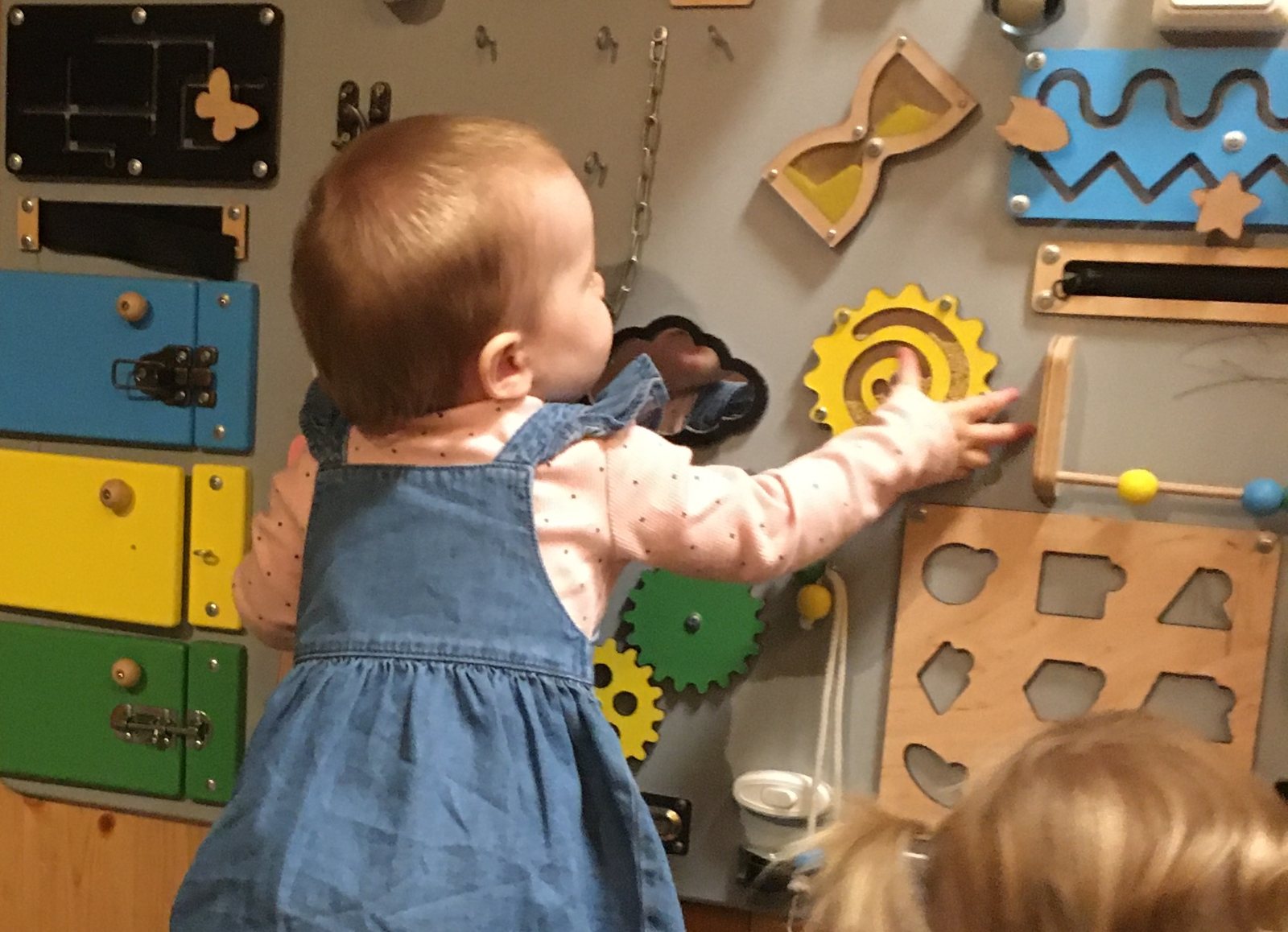 A toddler exploring the activity board