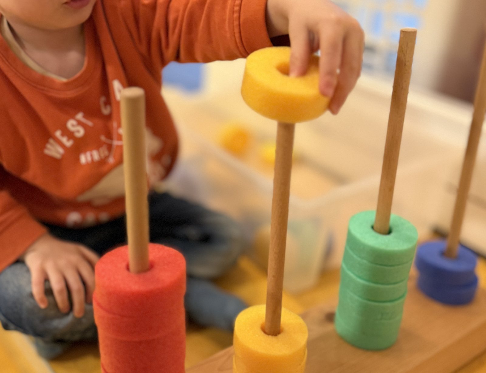 A child stacking colourful foam rings
