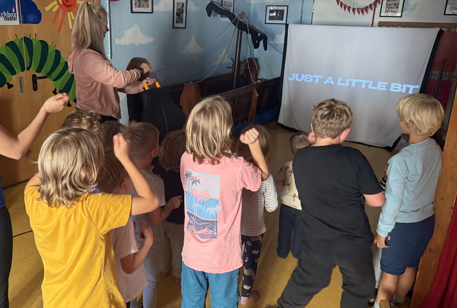 Children dancing in front of a screen