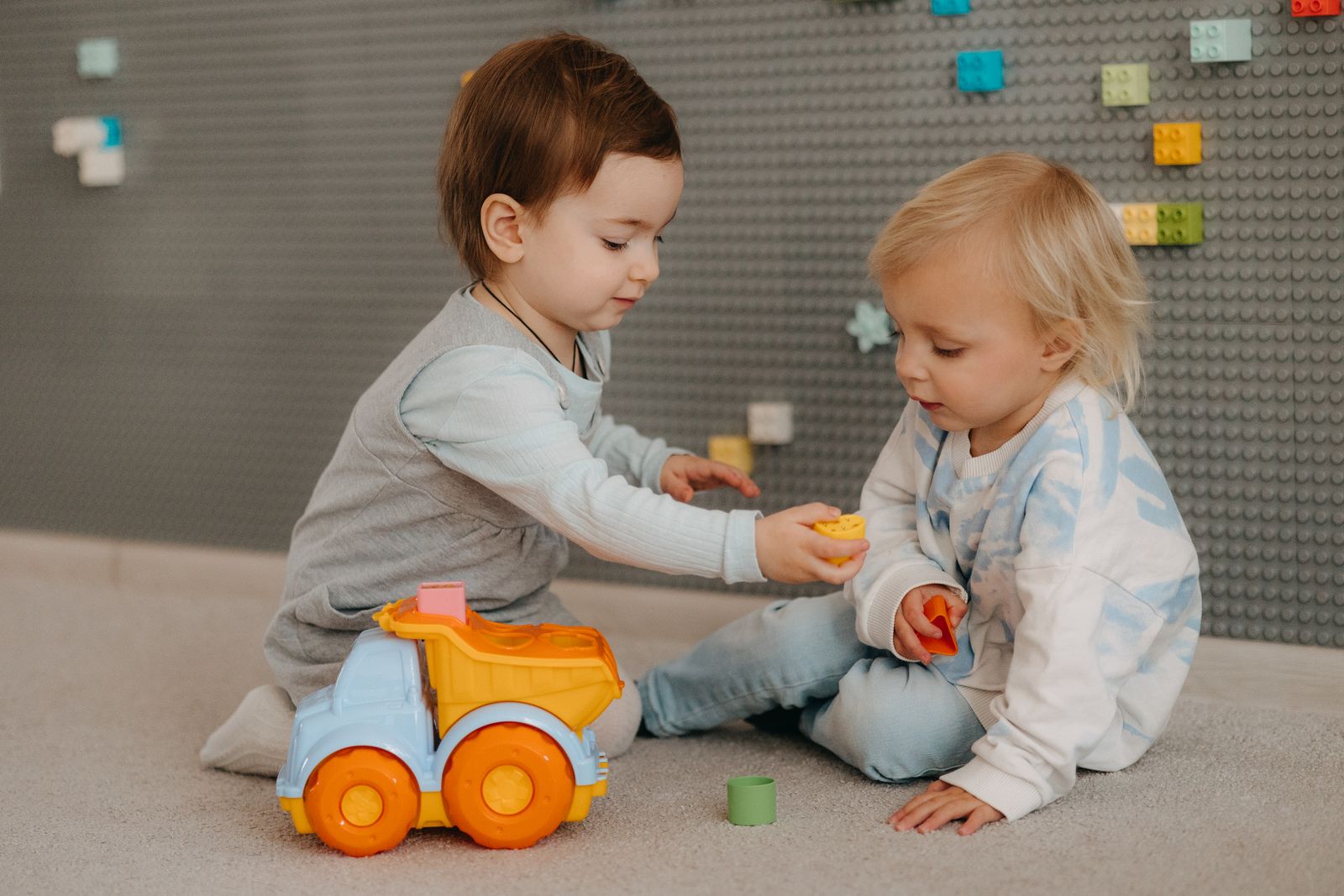 Zwei Kleinkinder spielen mit Bauklötzen