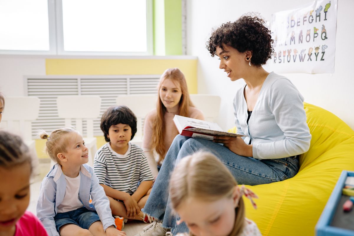 Erzieherin liest Kindern eine Geschichte vor
